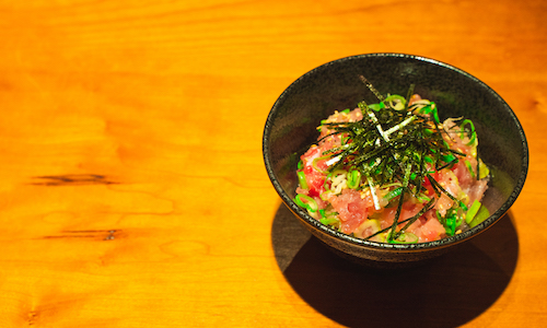 A bowl of rice topped with a generous amount of negitoro (green onion and tuna)